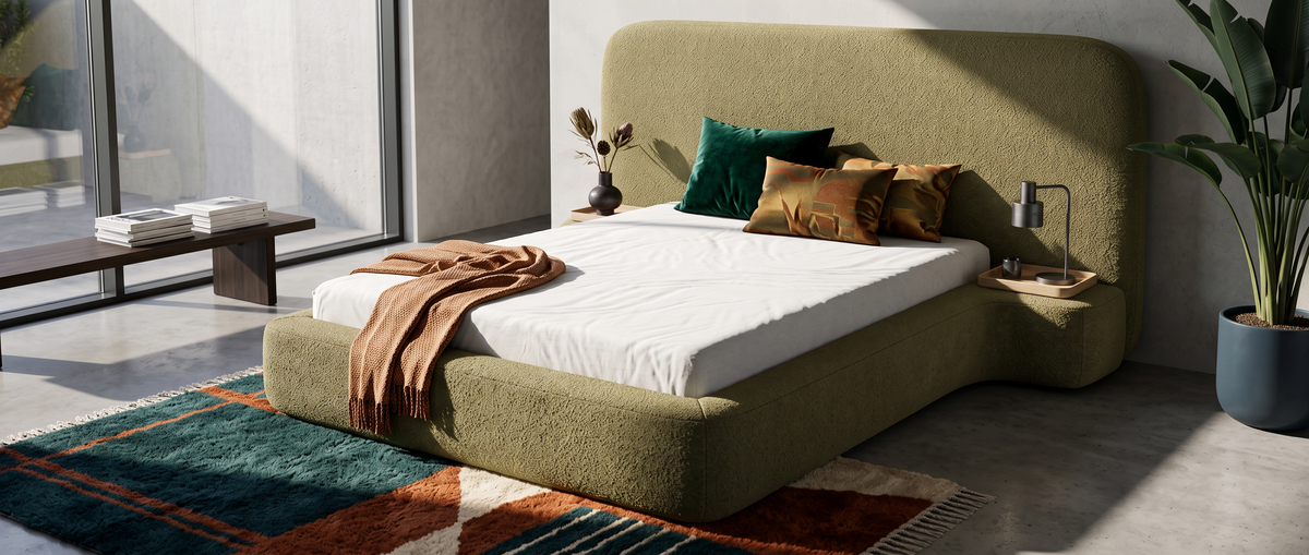 Modern bedroom with a green Genz bed, decorative cushions, a colourful rug and large windows letting in natural light