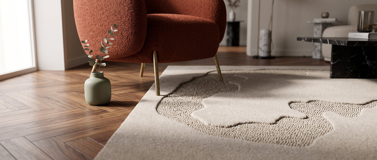 Modern living room with a Sorello rug with a subtle organic pattern, a wooden floor and a terracotta armchair