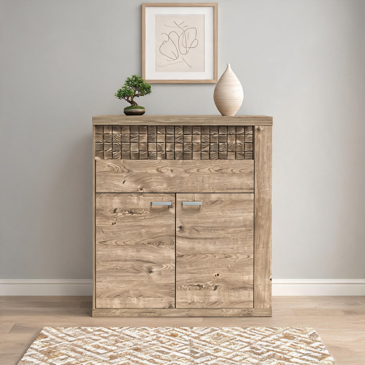 Commode Korin 102x119 contre un mur gris clair avec bonsaï et affiche – commode à tiroirs pour l'entrée ou le salon