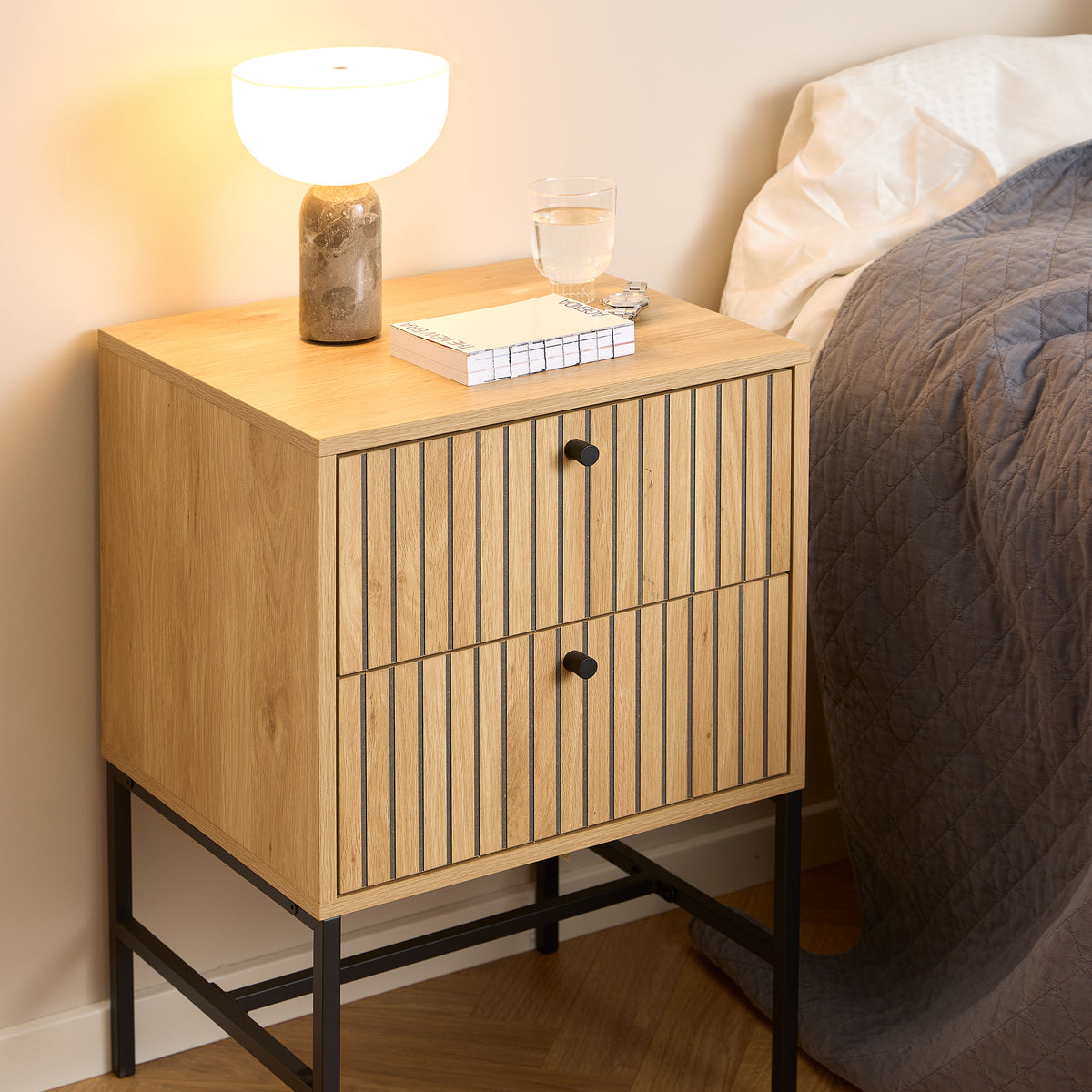 Table de chevet Bambouz 46 x 70 dans la chambre, à côté du lit, avec une lampe, des livres et un verre – table de chevet à tiroirs