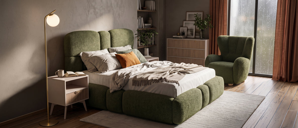 Cosy bedroom with a green Puffra upholstered bed and Tedi armchair, a wooden Mandala chest of drawers and bedside table and a gold Orbitella floor lamp