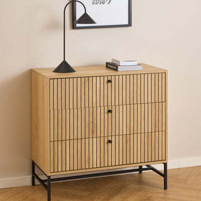 Commode Bambouz 81 x 81 devant une affiche murale, avec une lampe noire et des livres – commode à lamelles pour le salon