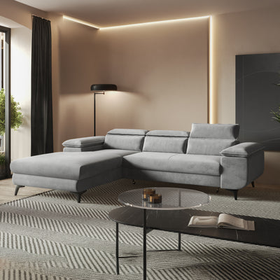 Canapé d'angle Bessi 276x205 Brume Grise (MONOLITH 84) dans un salon chaleureusement éclairé près d'une table en verre – canapé d'angle pour le salon