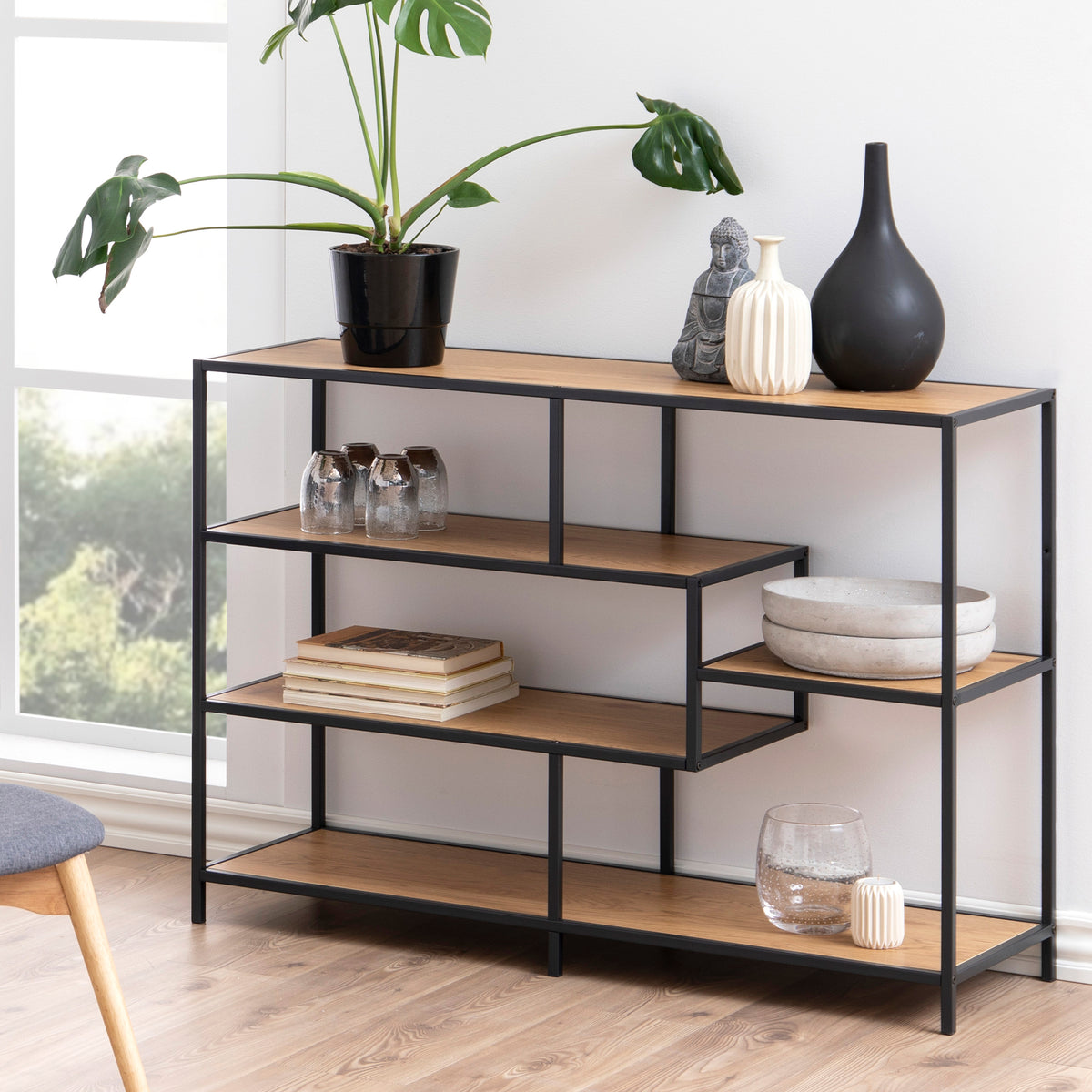 Étagère Skeleto 114 x 78 en chêne sauvage dans un salon lumineux près de la fenêtre, avec une plante, des vases et des livres – une étagère pour le salon