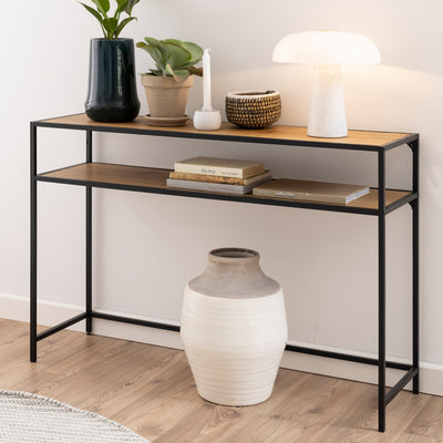 Console Skeleto 120 x 79 en chêne sauvage, placée contre un mur clair, avec une lampe, des plantes et des livres sur l'étagère – console pour l'entrée