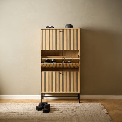 Meuble à chaussures Bambouz 72 x 141 dans l'entrée, au sol en chevrons – compartiment central à porte battante contenant les chaussures, tapis et décorations